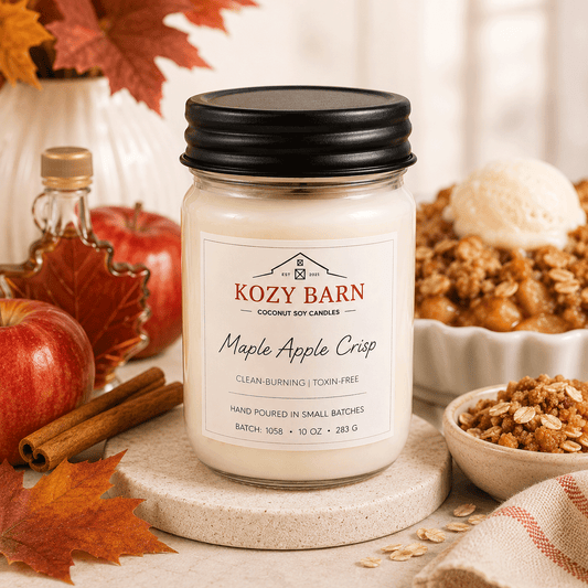 Kozy Barn candle labeled Maple Apple Crisp surrounded by apples, cinnamon, maple syrup, and ice cream.